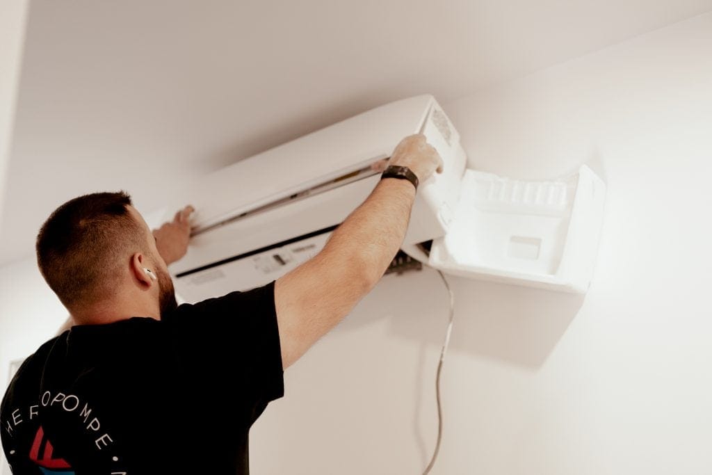 Technicien TCDF installant un climatiseur mural